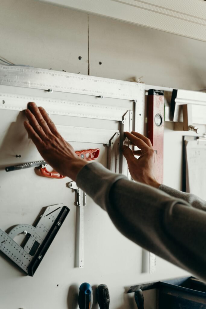 Hands using measuring tools on a wall in a workshop setting. Perfect for carpentry concept.